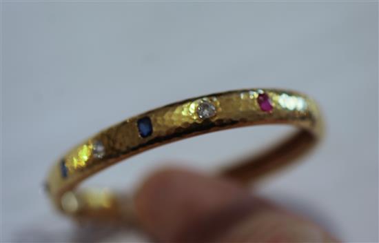 A planished 18ct gold, ruby sapphire and diamond hinged bangle, gross weight 20.4 grams.